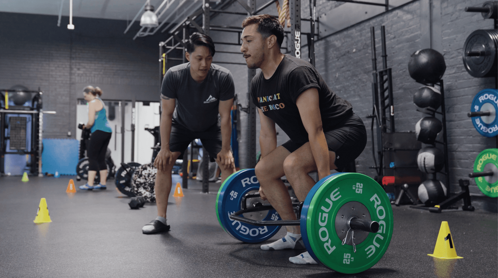 Personal training Oakland — coach guiding a client through a deadlift at Impact Fitness Oakland