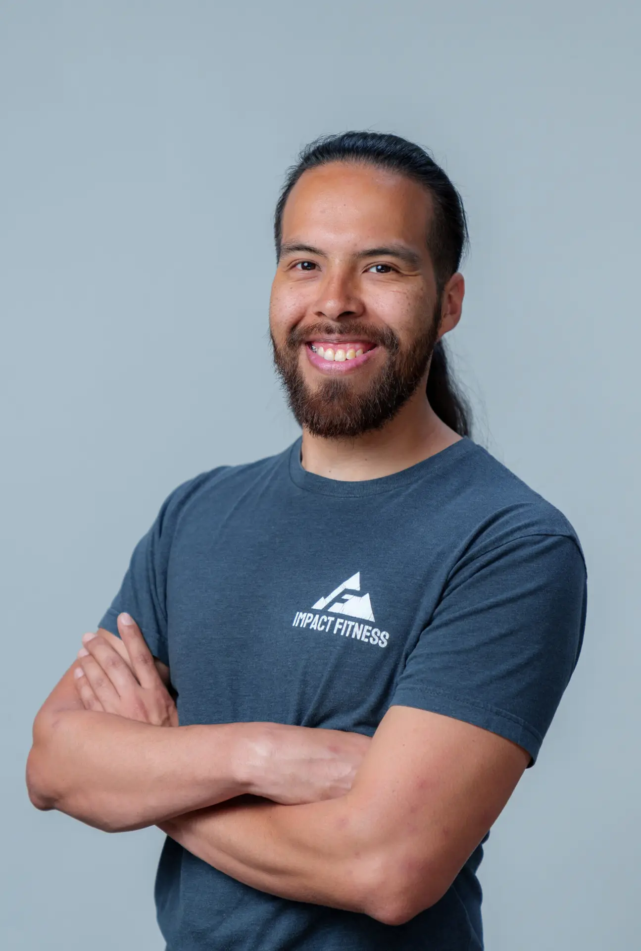 Ed Osorio, PPSC personal trainer at Impact Fitness Oakland, arms crossed and smiling