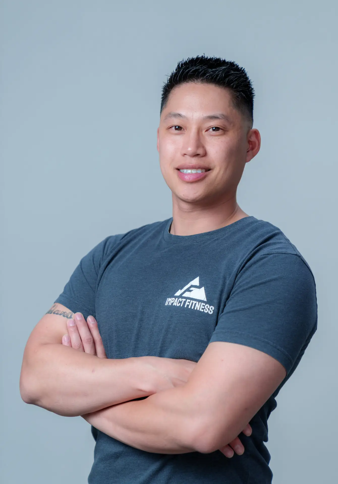 Liam Saechao, owner and master trainer at Impact Fitness Oakland, arms crossed