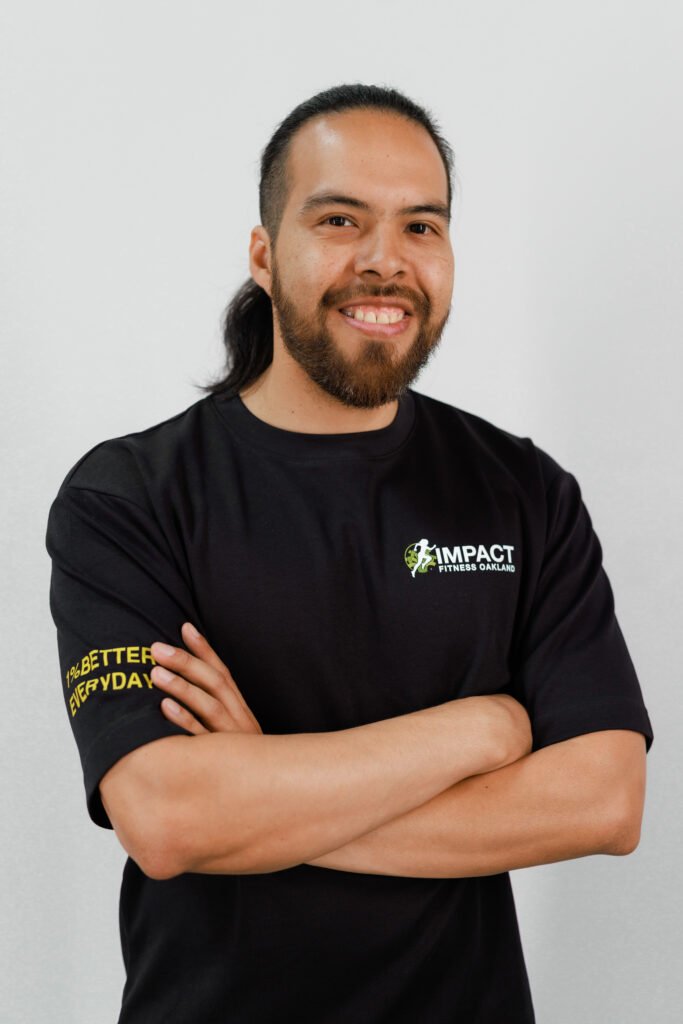 Ed Osorio, certified personal trainer at Impact Fitness Oakland, arms crossed and smiling