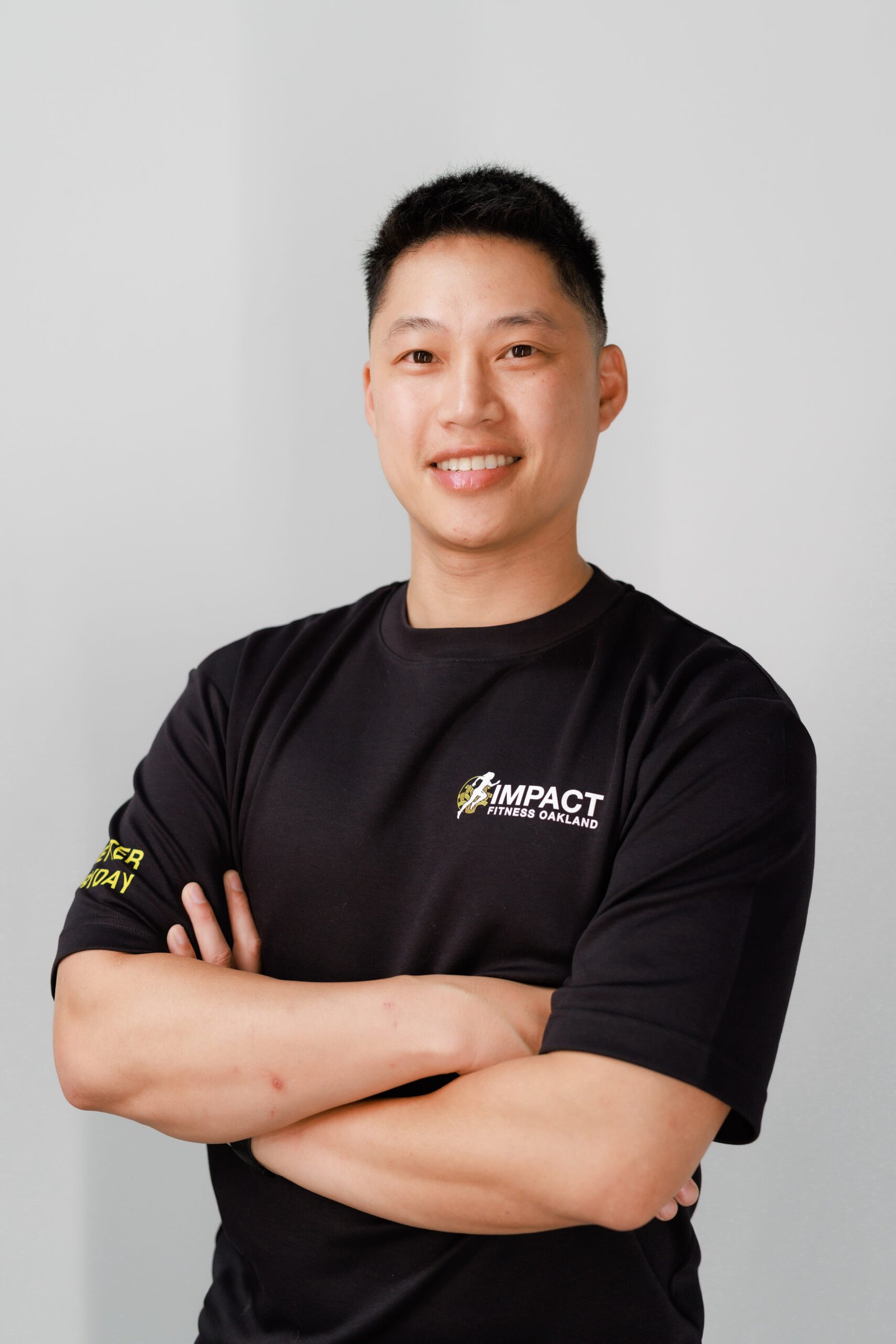 Liam Saechao, owner and master trainer, in a black Impact Fitness Oakland shirt